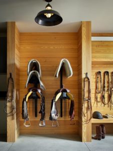 Western equestrian barn tack room with saddle racks.