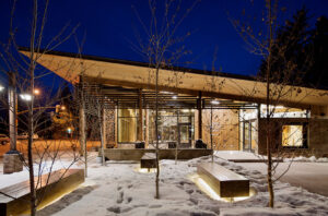 A modern Welcome Center in Jackson Hole glows under the night sky in winter.